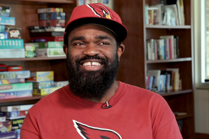 A.T. wearing red Cardinal's hat and smiling
