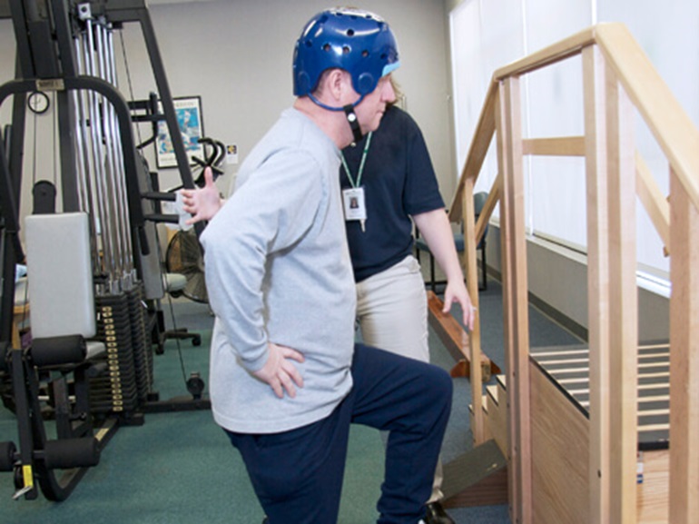 therapist with a patient doing stepping exercises for brain injury rehabilitation